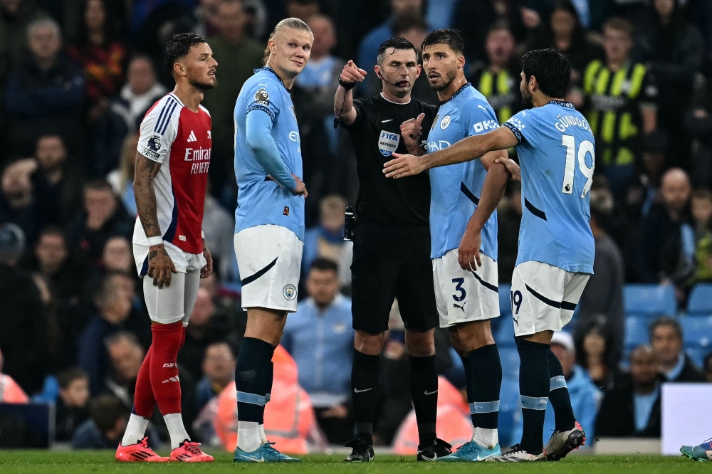 Manchester City’s Norwegian striker #09 Erling Haaland (2nd left) Manchester City’s Portuguese defender #03 Ruben Dias (2nd right) talks to English Referee Michael Oliver during the English Premier League football match between Manchester City and Arsenal at the Etihad Stadium in Manchester September 22, 2024. — AFP pic