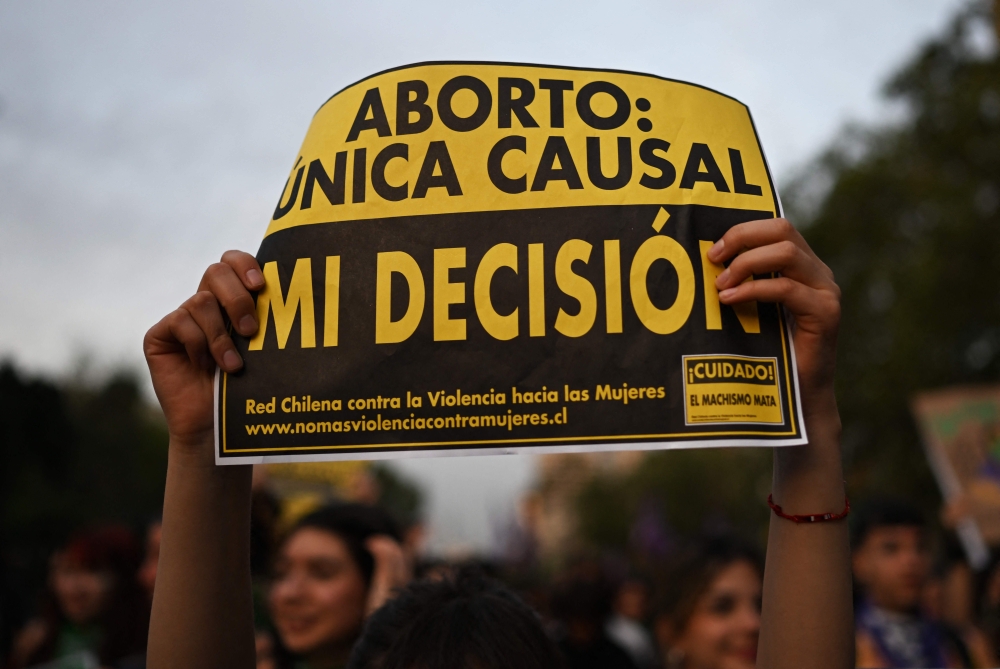 A demonstrator holds a sign reading in spanish ‘Abortion: only one cause, my decision’ during a rally in favor of decriminalising abortion as part of International Safe Abortion Day in Santiago September 27, 2024. — AFP pic