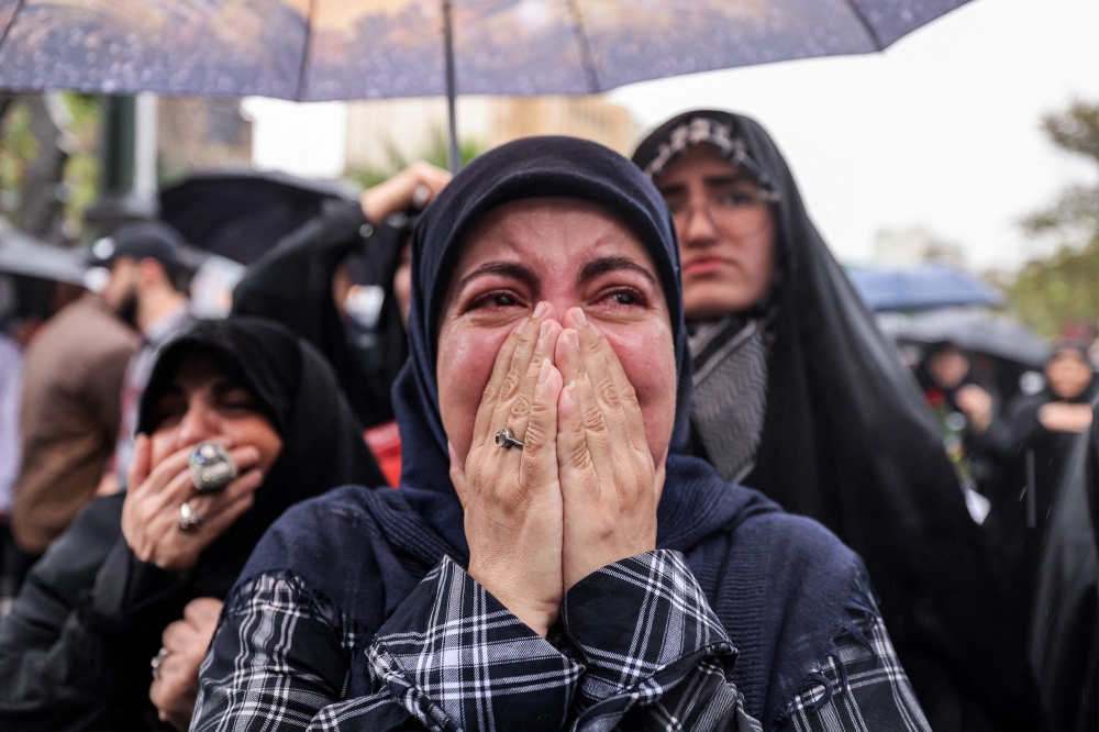 A woman reacts as she stands in the rain with other demonstrators during an anti-Israel protest in Tehran’s Palestine Square on September 28, 2024, after the Iran-backed Lebanese Hezbollah group confirmed reports of the killing of its leader Hassan Nasrallah in an Israeli air strike in Beirut the previous day. — AFP pic