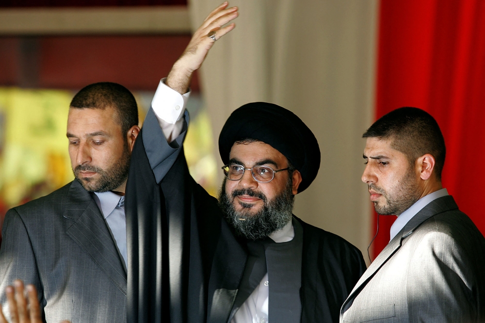 Hezbollah chief Hassan Nasrallah, flanked by two of his bodyguards, waves to the crowds at a rally in the southern suburbs of Beirut September 22, 2006. — AFP pic