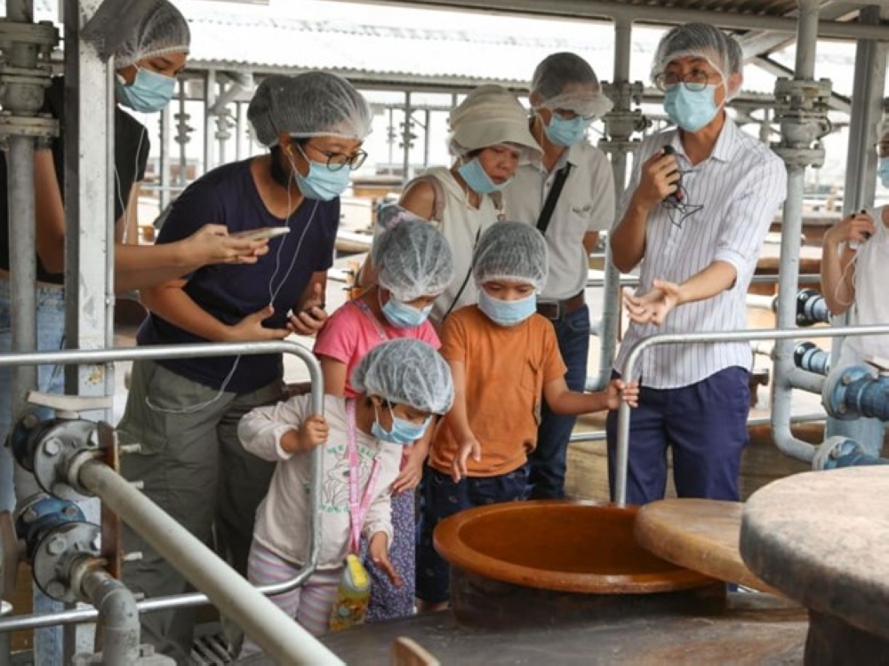 A guide explaining the soy sauce production process to participants at the Tai Hua soy sauce factory on July 26, 2024. — TODAY pic