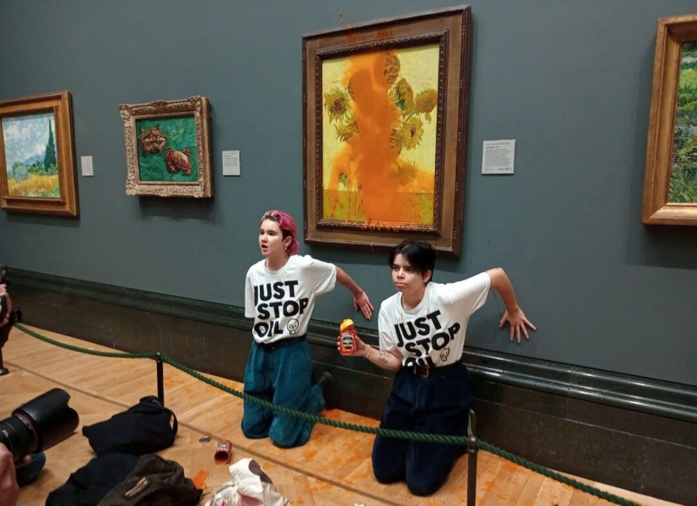 ‘Just Stop Oil’ activists glue their hands to the wall after throwing soup at a Van Gogh's painting ‘Sunflowers’ at the National Gallery in London October 14, 2022. — Handout via Reuters