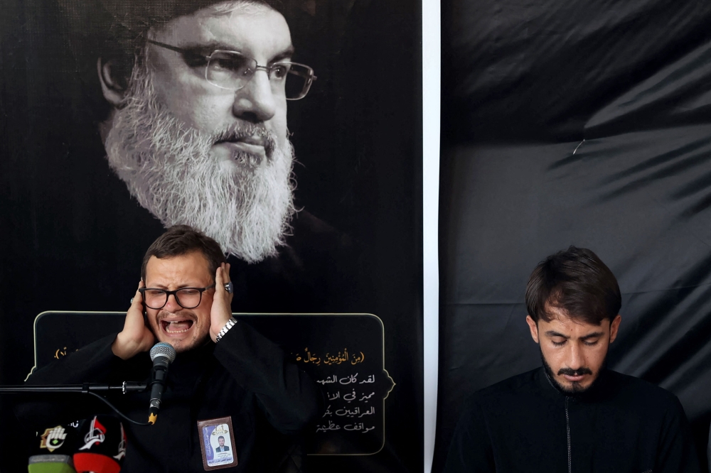 A man recites verses from the Quran during a memorial service for Hassan Nasrallah, the late leader of the Lebanese group Hezbollah who was killed in an Israeli air strike in Beirut days earlier, in Iraq’s central holy shrine city of Karbala on September 29, 2024. — AFP pic 