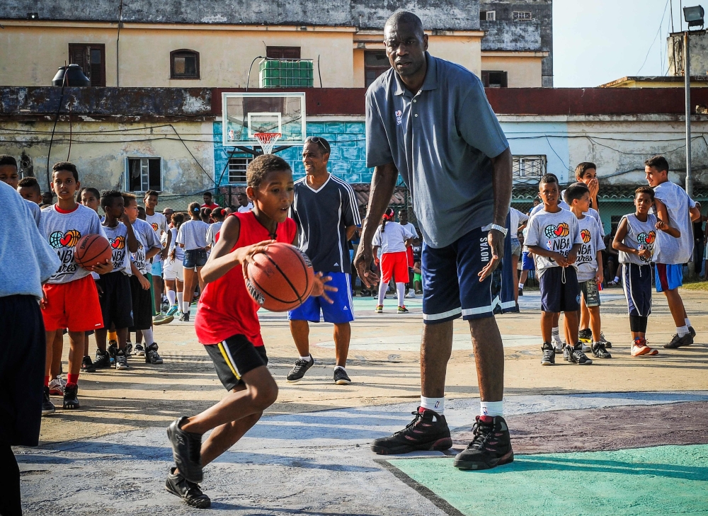 Former NBA basketball player Dikembe Mutombo (C) gives instructions to Cuban children during clinical organized by the NBA, FIBA Americas and Cuban Basketball Federation on April 24, 2015, in Havana.