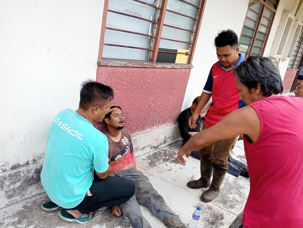 Residents of Felda Tenggaroh 5 treat Zalini Dahlan after the elephant attack near Mersing on September 26, 2024. — Picture courtesy of Sahabat Anak Tenggaroh Facebook page
