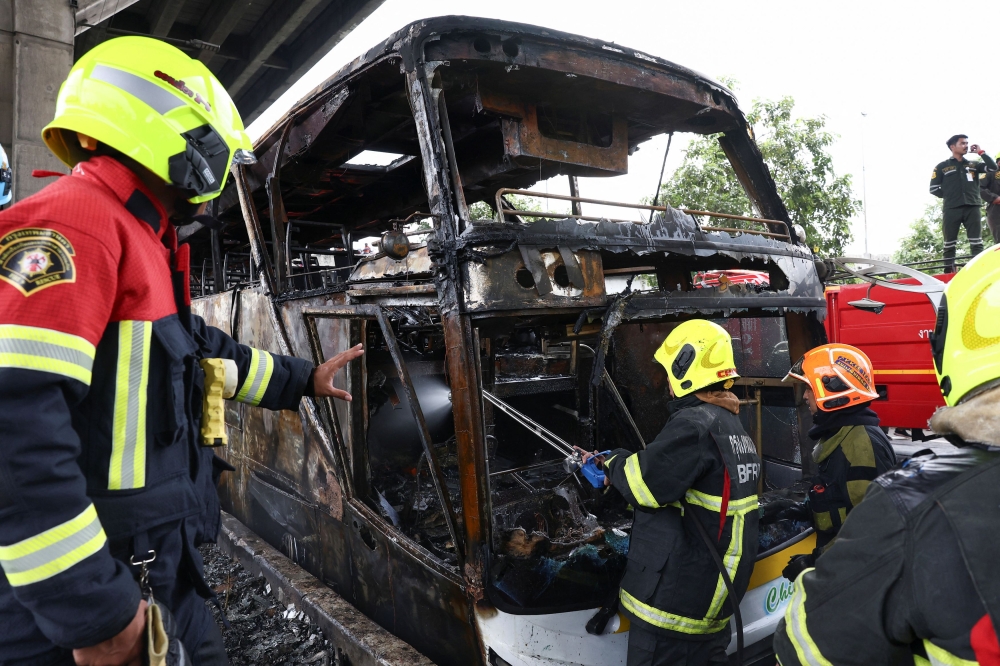 Firefighters work to extinguish a burning bus that was carrying teachers and students from Wat Khao Phraya school, reportedly killing almost a dozen, on the outskirts of Bangkok, Thailand, October 1, 2024. — Reuters pic