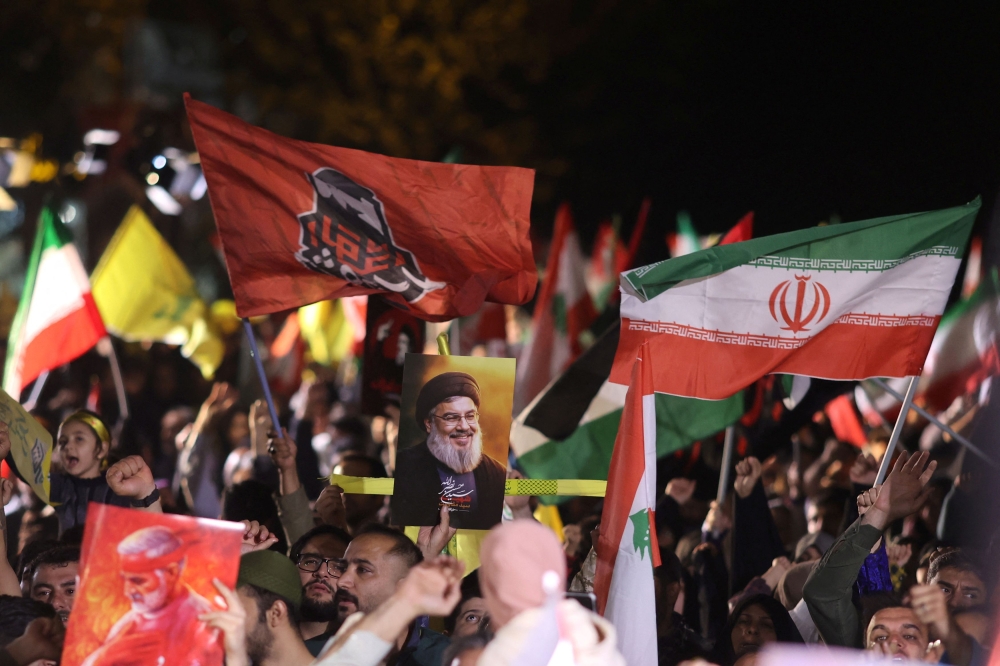 Iranians celebrate on a street after the IRGC attack on Israel, in Tehran, Iran. — Reuters pic