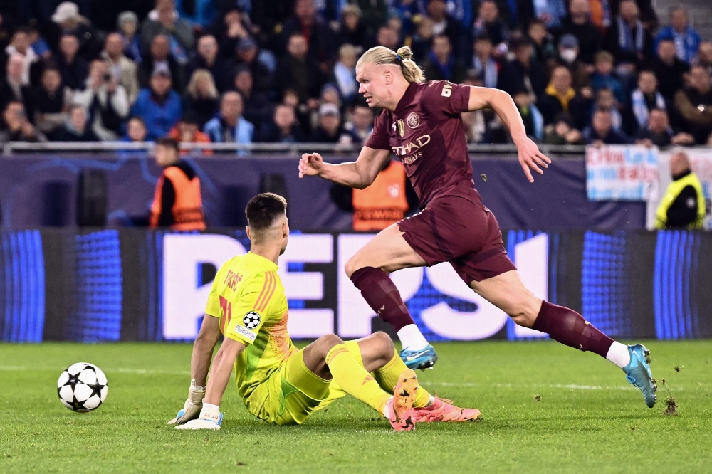 Manchester City's Norwegian striker Erling Haaland runs for the ball before scoring his team's third goal past Slovan Bratislava's Slovak goalkeeper Dominik Takac during their UEFA Champions League football match yesterday. — AFP pic