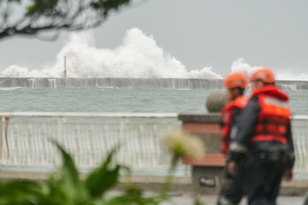 Members of the Taiwan Coast Guard walk along the coast at Sizihwan beach in Kaohsiung October 2, 2024. — AFP pic