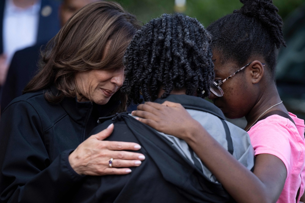 US Vice President Kamala Harris embraces community members as she surveys the damage from Hurricane Helene, in the Meadowbrook neighbourhood of Augusta, Georgia, October 2, 2024. — AFP pic