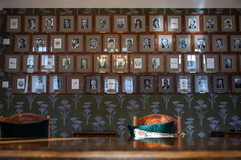 A photo taken on September 25, 2024 shows portraits of individual laureates and the logos of prize-winning institutions and organisations on a wall of the committee meeting room at the Norwegian Nobel Institute in Oslo. — AFP pic