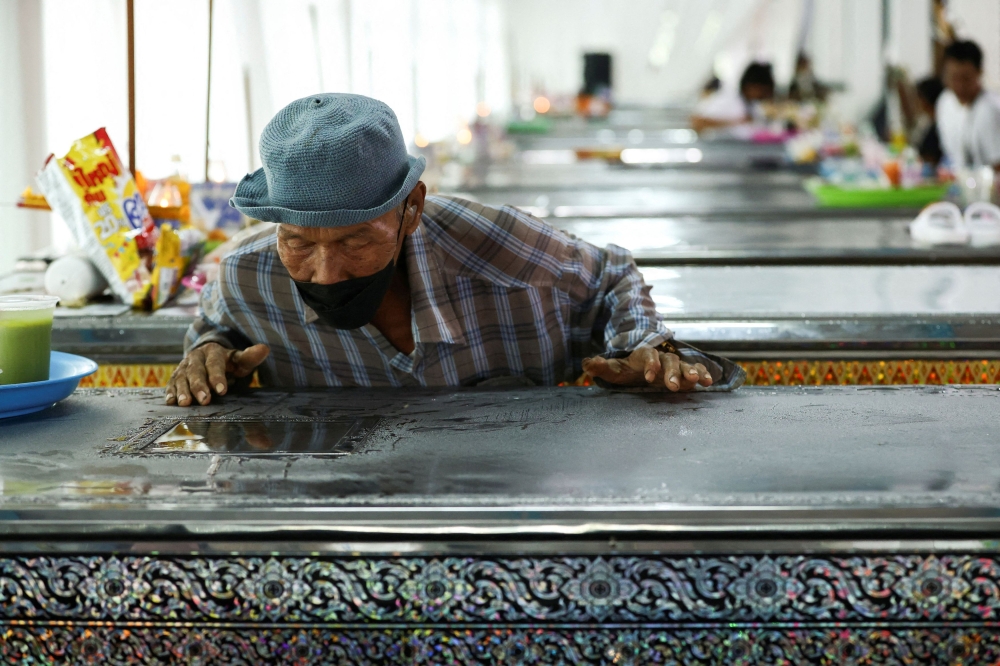 A family member attends a funeral for children who had been studying in Wat Khao Phraya School and were killed in a bus which was engulfed in a fire while on a school field trip in Bangkok, in Uthai Thani province, Thailand, October 3, 2024. — Reuters pic