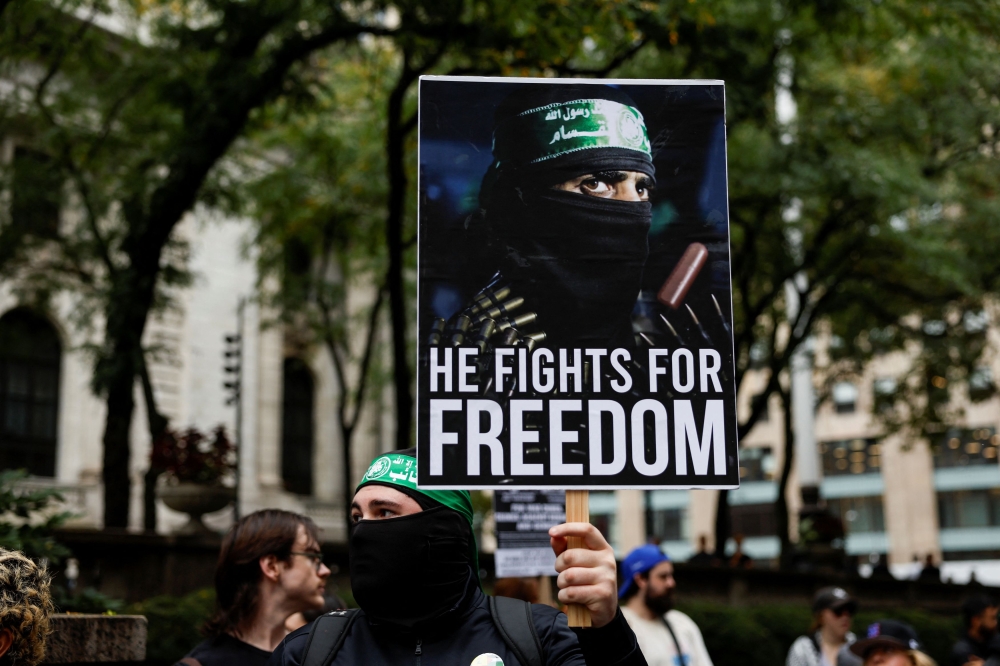 A man wearing a headband of Hamas’ armed wing Al-Qassam Brigades holds a placard, as Pro-Palestinian protesters rally against Israel’s strikes on Gaza and Lebanon during demonstrations in New York City, September 26, 2024. — Reuters pic