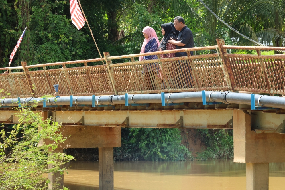 Sabari Baharom's widow Subhiah Ruslina Shahibi with family members visiting the scene of her husband's murder at Jambatan Kampung Empa. — Bernama pic