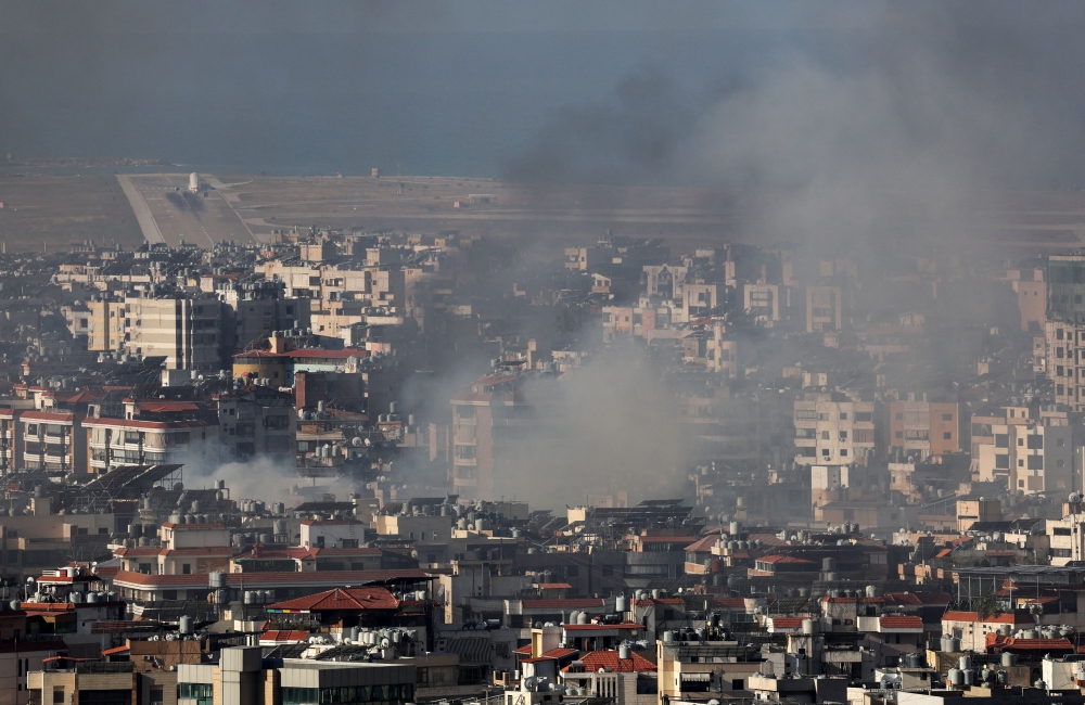 An airplane takes off at Beirut-Rafic Hariri International Airport as smoke rises over Beirut's southern suburbs after a strike, amid the ongoing hostilities between Hezbollah and Israeli forces, as seen from Sin El Fil, Lebanon October 2, 2024. A South Korean military transport aircraft is evacuating 97 citizens and family members from Lebanon amid escalating tension and will return to South Korea this afternoon. — Reuters pic  