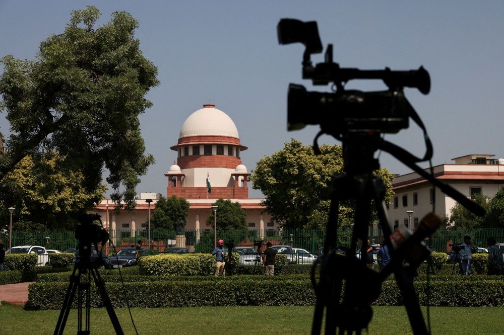Members of media speak in front of cameras outside the premises of the Supreme Court in New Delhi October 13, 2022. India’s government has insisted that marital rape should be treated more leniently than other rape offences in an ongoing Supreme Court case brought by campaigners seeking to outlaw it. — Reuters pic  