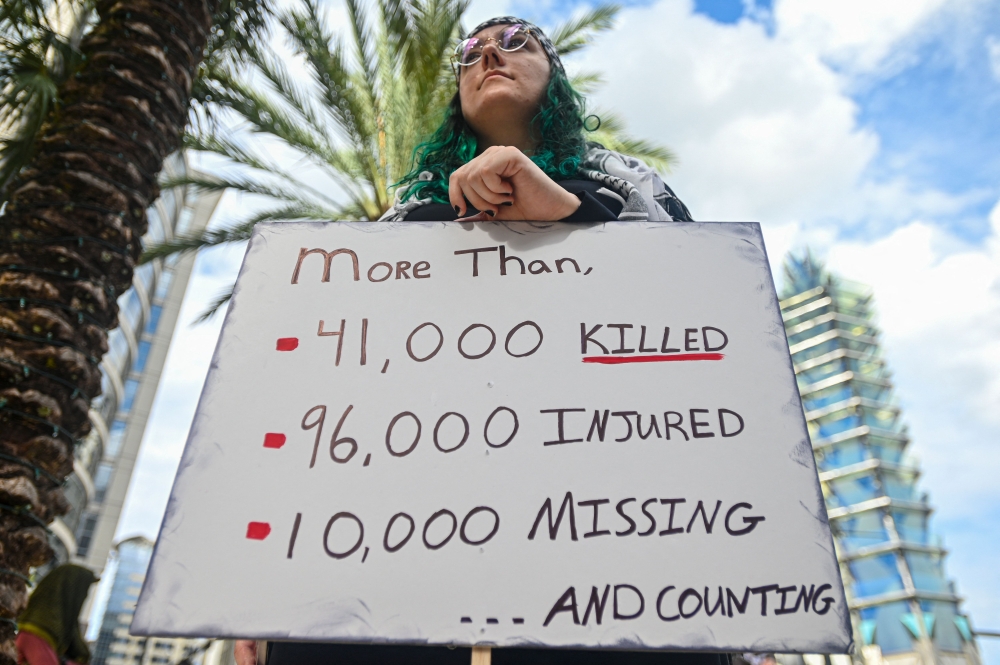 A pro-Palestinian protester holds a sign during rally in support of Gaza and Lebanon to mark one year of the war between Hamas and Israel in Orlanda, Florida, on October 5, 2024. — AFP pic