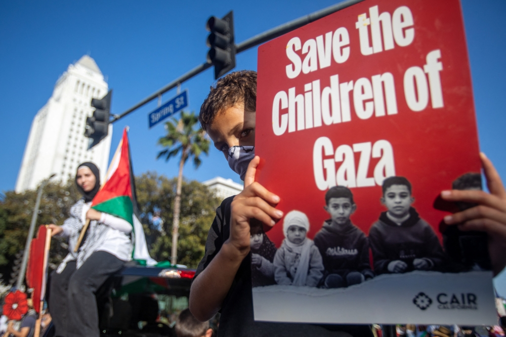 A young protestor holds a sign reading ‘Save the Children of Gaza’ as people demonstrate to mark one year of the war between Hamas and Israel in Los Angeles October 5, 2024.  Fast approaching the one-year anniversary of the Hamas-led October 7, 2023, surprise attack in southern Israel, the war has resulted in over 41,000 deaths in Gaza. — AFP pic