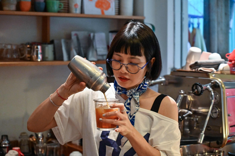 This photo taken on August 21, 2024 shows coffee house owner Nguyen Thi Hue making a drink during an interview at her cafe in Hanoi. Traditionally taken black, sometimes with condensed milk, salt or even egg, coffee has long been an integral part of Vietnamese culture. — AFP pic