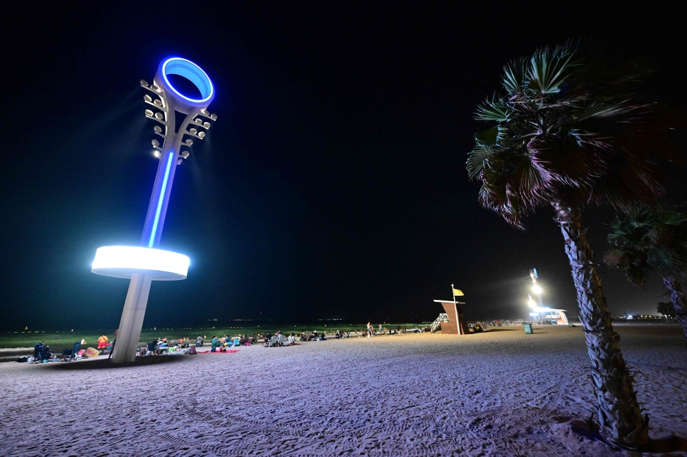 A floodlight is installed to illuminate the Umm Suqeim beach for beachgoers in Dubai during the night of October 5, 2024. Roasted by summer temperatures too hot for the beach, Dubai has turned to an innovative solution: opening them at night, complete with floodlights and lifeguards carrying night-vision binoculars. — AFP pic