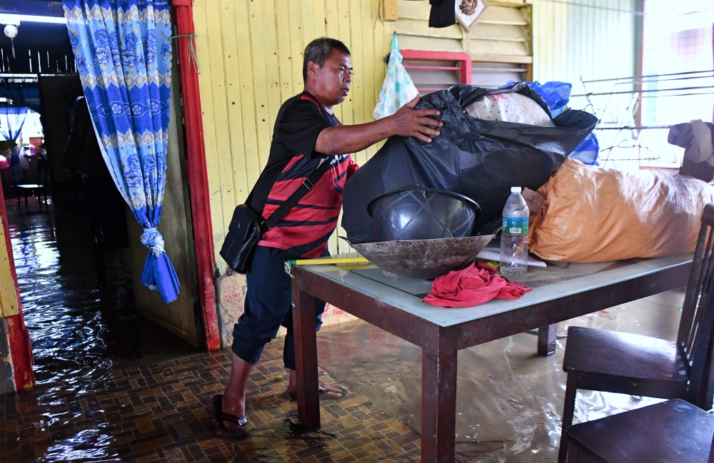Everything drenched: Flood-hit resident Azizon Mohammad @ Lau Kong Seng, 50, gets down to cleaning up his Batu 8, Jebong Kiri, Matang in Perak. — Bernama pic