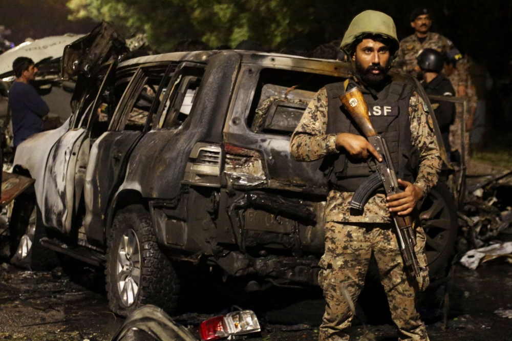 A member of the Airport Security Force ASF stands guard near the wreckage of vehicles after an explosion near Jinnah International Airport in Karachi, Pakistan October 6, 2024. — Reuters pic