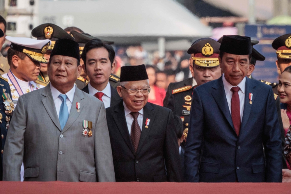 Indonesia's President Joko Widodo (right), Vice President Ma'ruf Amin (second right), Defence Minister and president-elect Prabowo Subianto (left) and vice president-elect and the incumbent President's son Gibran Rakabuming Raka (second left) arrive to attend celebrations marking the 79th anniversary of the Indonesian Armed Forces (TNI) in front of the National Monument (MONAS) at Merdeka Square in Jakarta on October 5, 2024. — AFP pic