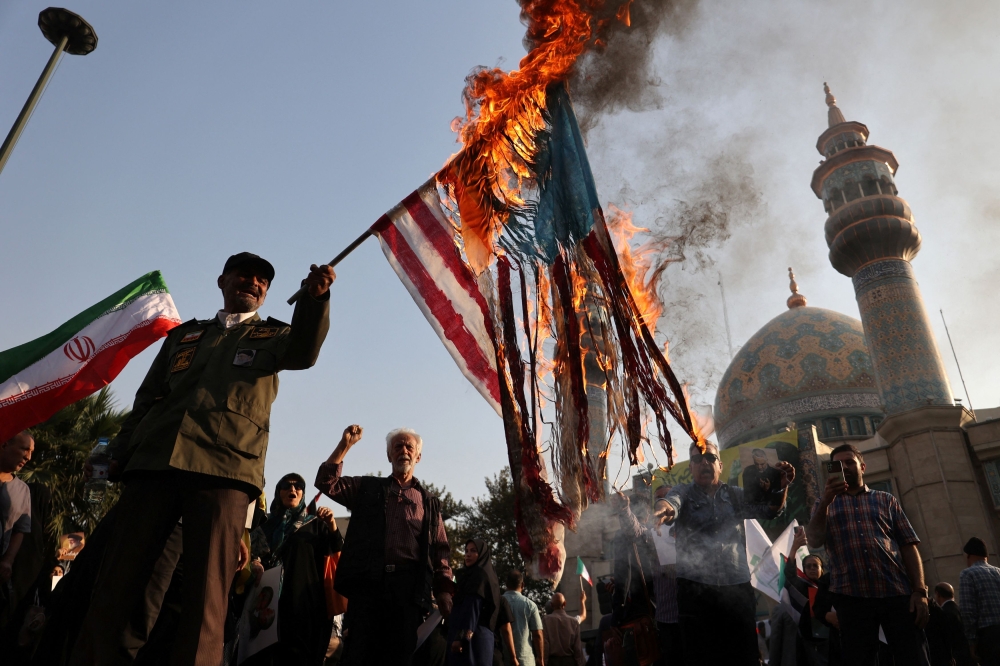 Iranians burn a US flag during an anti-Israel gathering in Tehran, Iran yesterday. — Reuters pic
