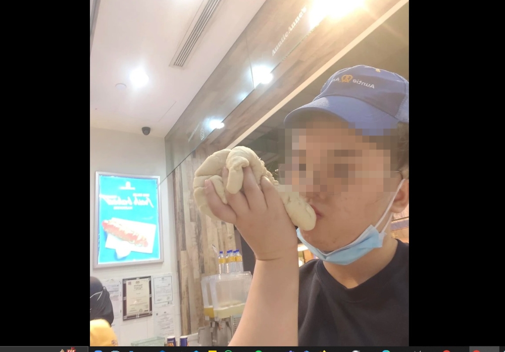 A picture of the  Auntie Anne’s Malaysia employee sniffing and kissing dough. — Picture from social media  