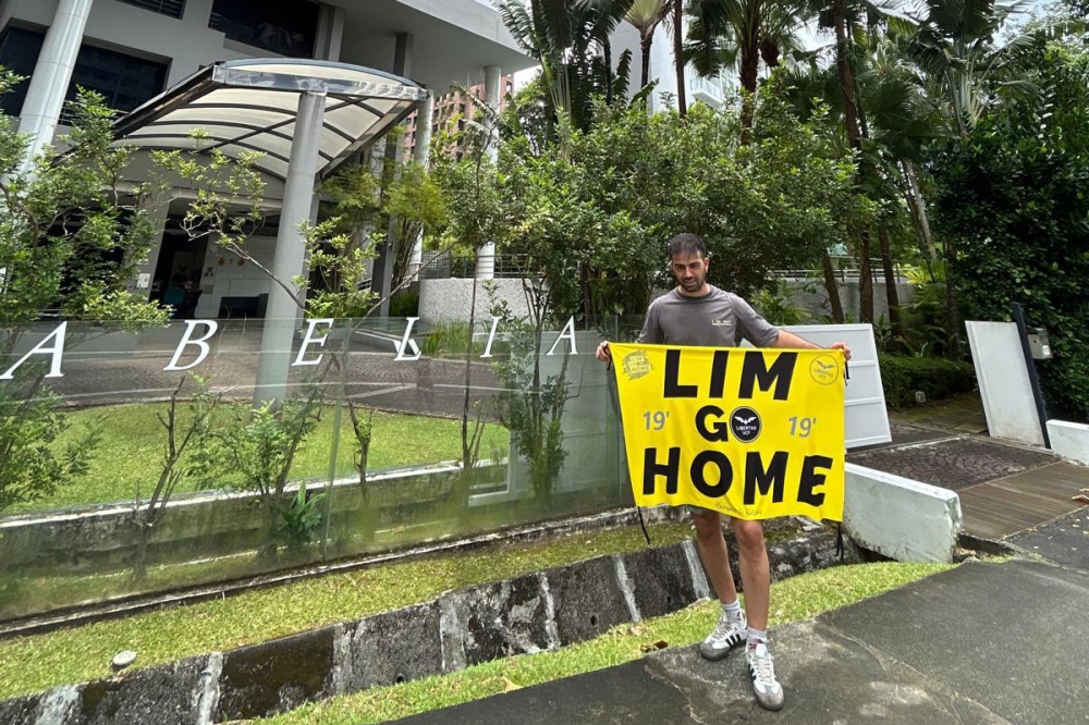 Dani Cuesta was in Singapore holding a black and yellow banner that read “Lim go Home” including outside the businessman's home. — Picture from X/Dani Cuesta