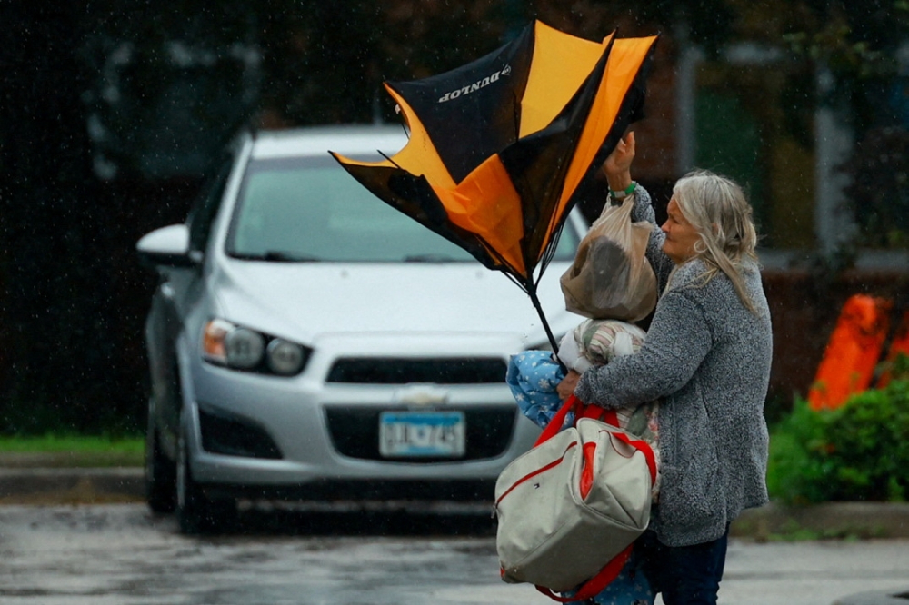 A woman holds an umbrella while arriving at a shelter as Hurricane Milton approaches, in Lakeland, Florida October 9, 2024. — Reuters pic