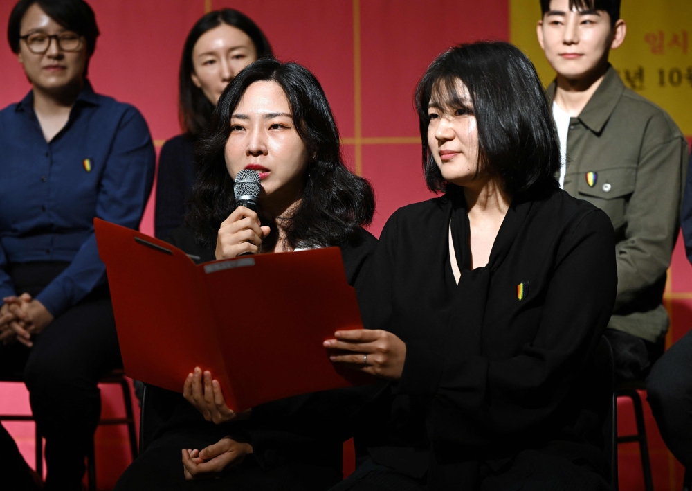Kim Sae-yeon (L) and her partner Kim Kyu-jin (R) speak during a press conference about same-sex marriage in Seoul on October 10, 2024. They are part of a group of same-sex couples planning to launch a new bid to force South Korea to legalise same sex marriage. — AFP pic