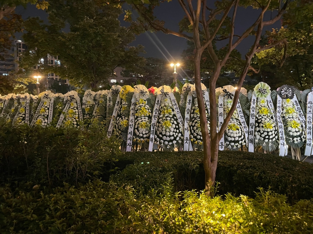 Dozens of funeral wreath with messages protesting the return of Seunghan line the outside of SM Entertainment's Seoul office. — Picture from X/302loverockstar