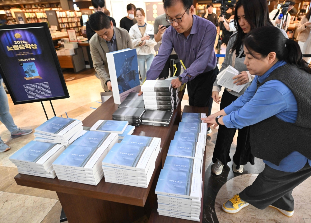 Salespeople display books by South Korean author Han Kang, who won the 2024 Nobel Prize in Literature, at a bookstore in Seoul yesterday. —  AFP