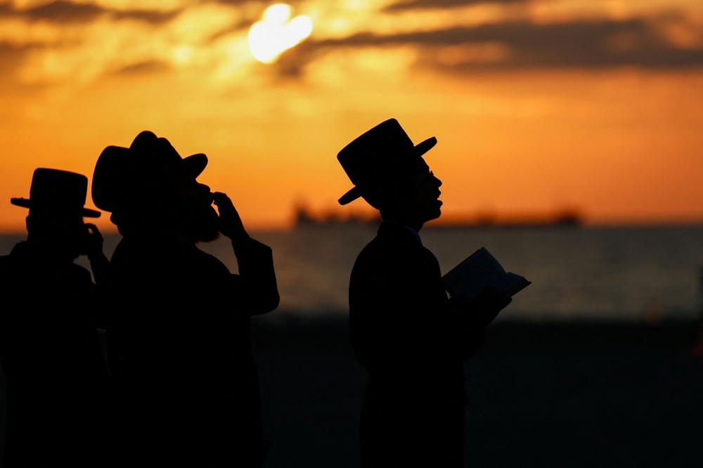 Ultra-Orthodox Jewish men perform the Tashlich ritual of symbolically casting away sins, ahead of Yom Kippur, the Jewish Day of Atonement in Ashdod, amid the ongoing conflict in Gaza between Israel and Hamas, Israel, October 10, 2024. — Reuters pic