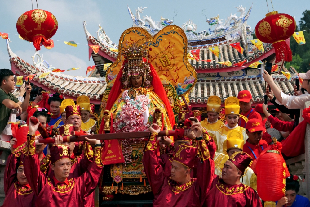 Pilgrims carry a sedan chair holding a statue of the sea goddess Mazu out of a temple during a pilgrimage on Meizhou island, Fujian province, China October 11, 2024. — Reuters pic