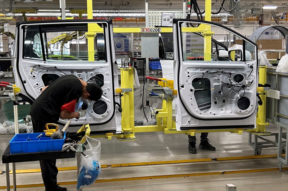 Employees work on an electric vehicle (EV) production line during an organised media tour to a factory under Jiangling Group Electric Vehicle (JMEV), in Nanchang, Jiangxi province May 22, 2024. — Reuters pic  