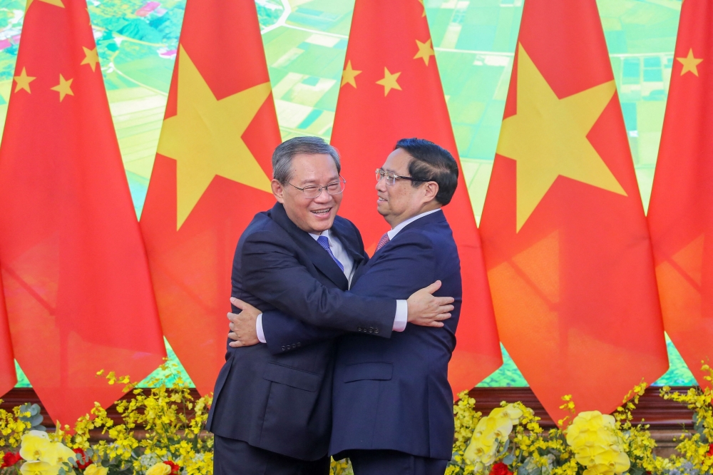 Vietnam’s Prime Minister Pham Minh Chinh (right) and China’s Premier Li Qiang hug as they pose for photos during a meeting at the Government Office in Hanoi on October 13, 2024. — AFP pic