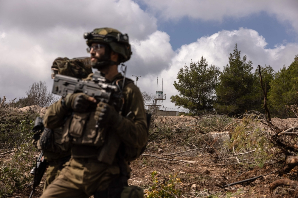This picture taken on October 13, 2024 during a controlled embed organised by the Israeli military, shows Israeli troops patrolling near a United Nations Interim Force In Lebanon (Unifil) base in the southern Lebanon’s Naqoura region near the border.