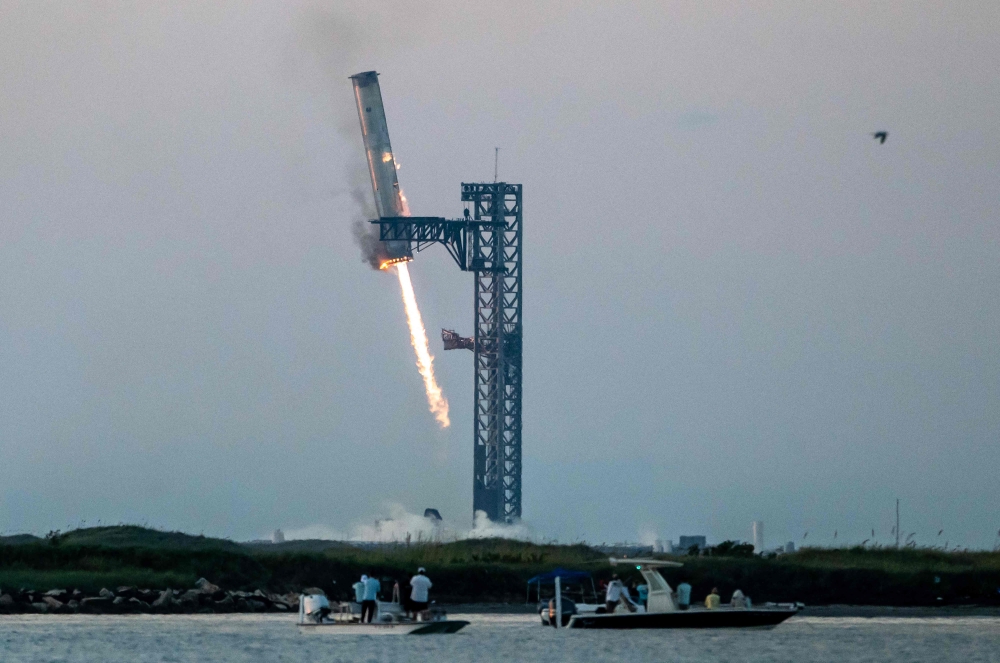 SpaceX successfully ‘caught’ the first-stage booster of its Starship megarocket Sunday as it returned to the launch pad after a test flight, a world first in the company’s quest for rapid reusability.