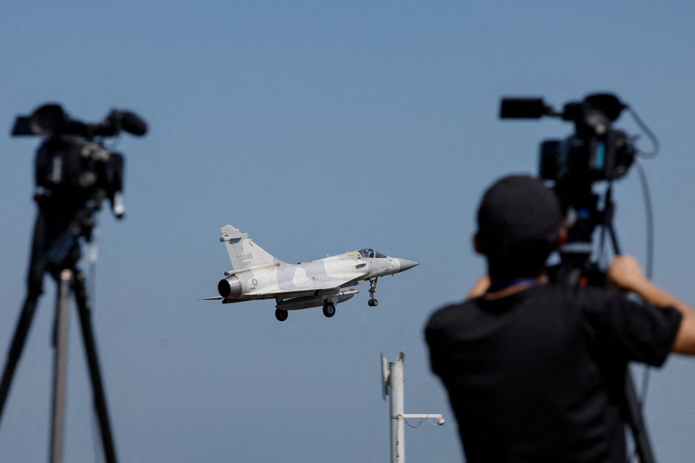 A member of the media takes a video of a Taiwan Air Force Mirage 2000 aircraft preparing to land at Hsinchu Air Base in Hsinchu, Taiwan October 14, 2024. — Reuters pic