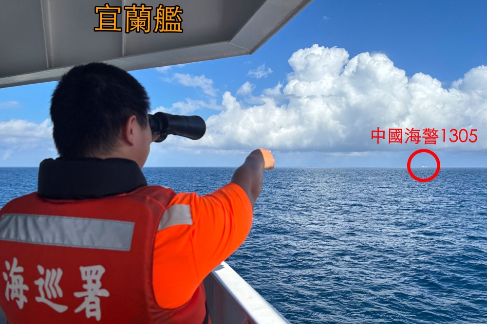 This photo taken and released by the Taiwan Coast Guard on October 14, 2024 shows a Taiwan Coast Guard personnel using binoculars on a petrol ship off Pengjia Islet (Keelung) while pointing at a Chinese Coast Guard ship sailing in the distance outside Taiwan’s territorial waters. — AFP pic