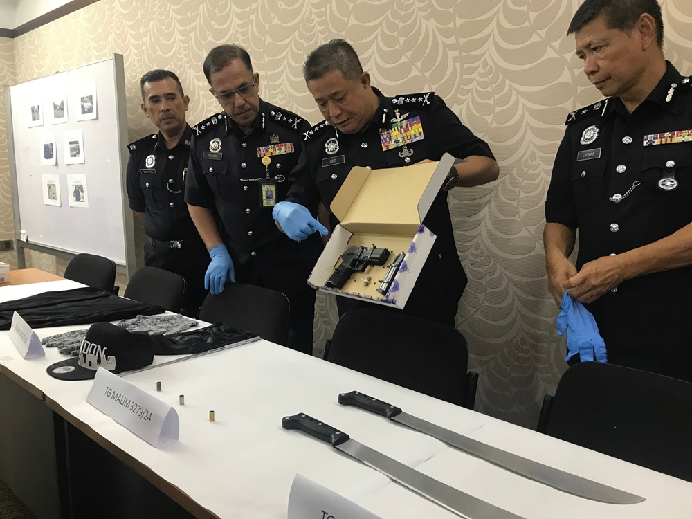 Perak police chief Datuk Azizi Mat Aris shows the weapons and items seized by police during a shootout incident in Tanjung Malim at a press conference at the Perak Police Headquarters in Ipoh October 14, 2024. — Bernama pic
