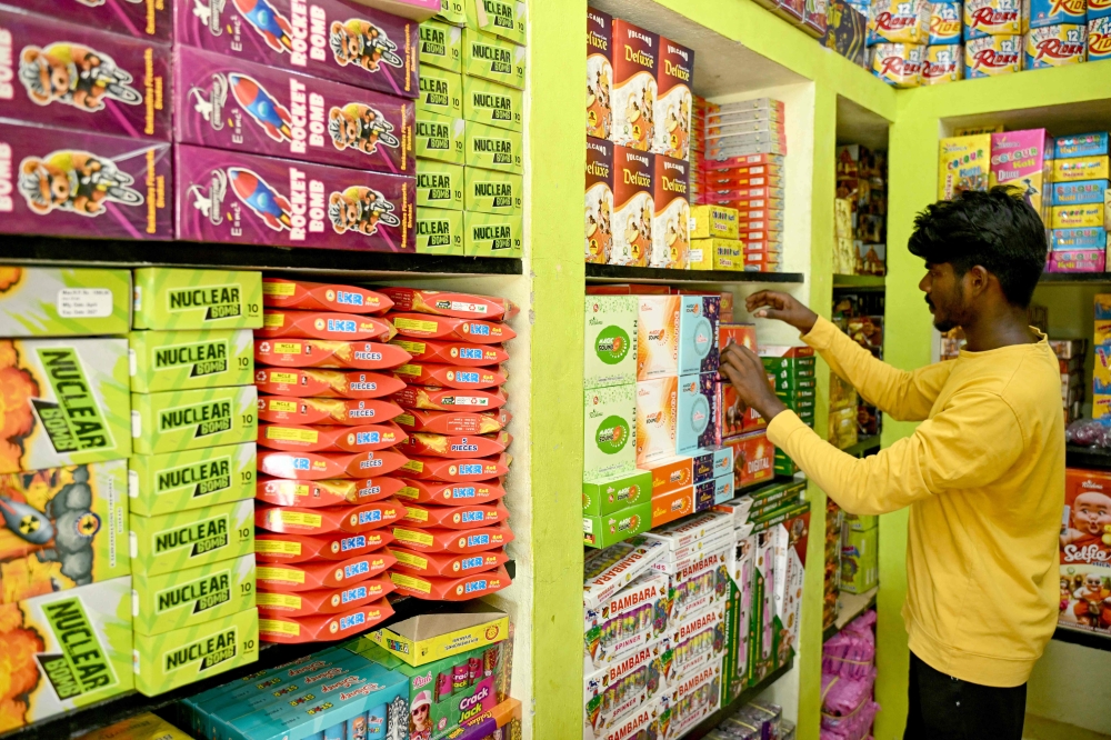 In this photograph taken on September 26, 2024, a worker arranges firecrackers for sale, at a shop on the outskirts of Sivakasi in India's Tamil Nadu state, ahead of Diwali, the Hindu festival of lights. Fireworks are a key part of celebrations for the Hindu festival of Diwali, which this year falls on November 1. — AFP pic