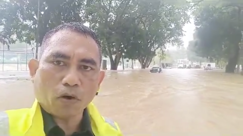 A screengrab of a video by UM personnel in which the flooded entrance to the campus can be seen in the background.
