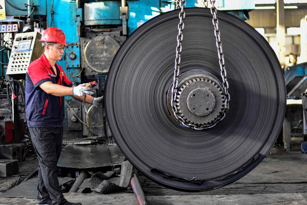 An employee works at a factory producing stainless steel materials in Qingzhou, in eastern China's Shandong province October 13, 2024. — AFP pic
