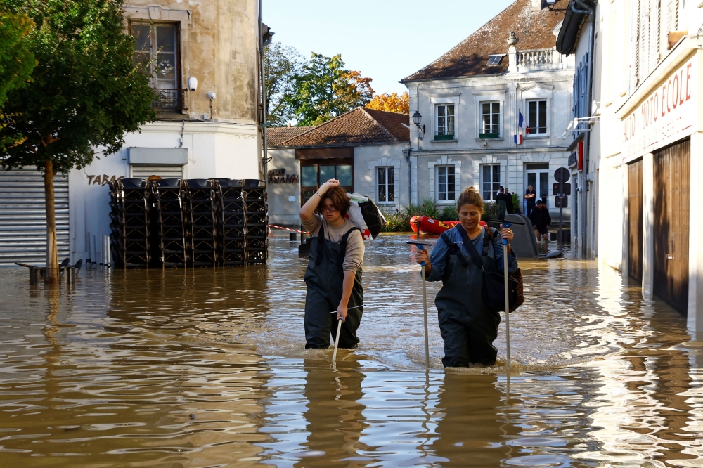 Residents walk in a flooded street in Crecy-la-Chapelle, Seine-et-Marne department, after heavy rain and the passage of the storm Kirk caused flooding over the country, France, October 11, 2024. — Reuters pic