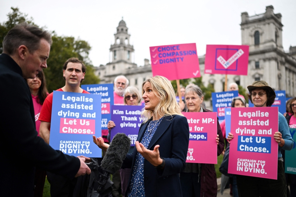 Labour MP Kim Leadbeater speaks to the press during a gathering in favour of the proposal to legalise euthanasia in the UK, called by campaigners from 'Dignity in Dying', outside The Palace of Westminster, home to the Houses of Parliament in central London, on October 16, 2024. — AFP pic