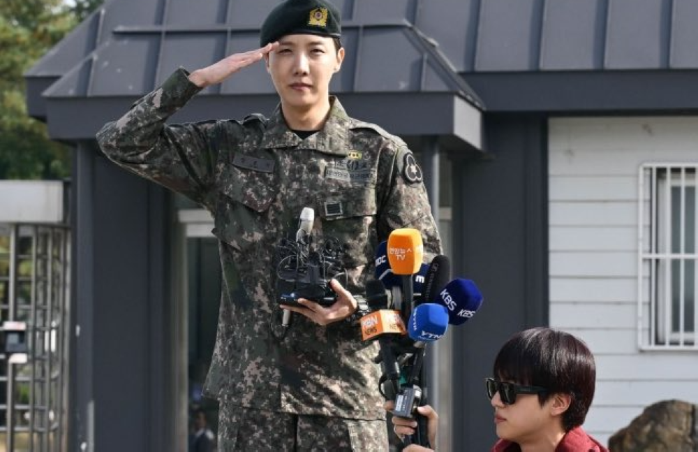 Fellow member Jin holds up microphones from media organisations for J-Hope. — Picture from X/btschartsdailyc