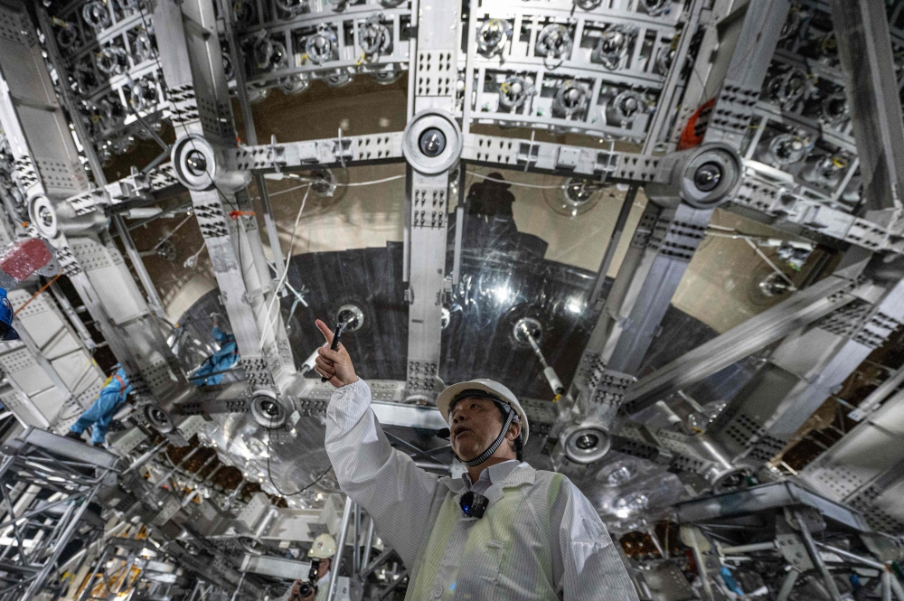 Scientist Wang Yifang, Juno project manager and director of the Institute of High Energy Physics at the Chinese Academy of Sciences, introducing the neutrino detector, a stainless steel and acrylic sphere around 35 metres in diameter, at the Jiangmen Underground Neutrino Observatory (Juno) in Kaiping, in southern China's Guangdong province. — AFP pic